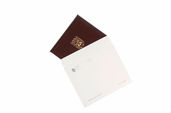 A white envelope with a brown passport on top of it.