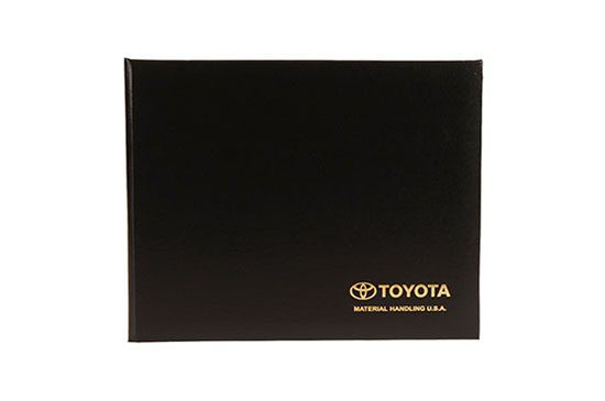 A black toyota book with gold lettering.